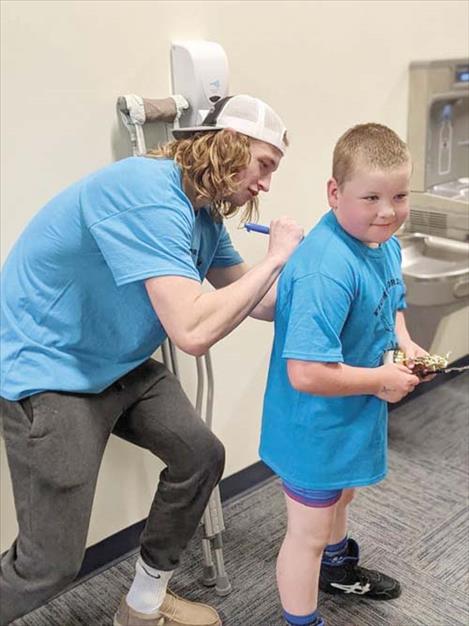  After winning first place in his age bracket during the “Fight for Isaiah” fundraising wrestling tournament, young wrestler William Sharbono nabs another trophy an Isaiah Allik autograph.