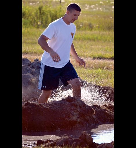 Derek Kramer splashes through the mud bog.