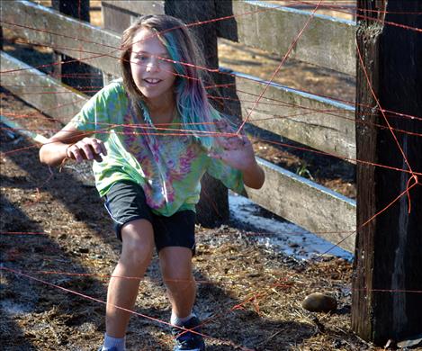 Jessie Griffith, 11, climbs through a watery maze of baling twine.