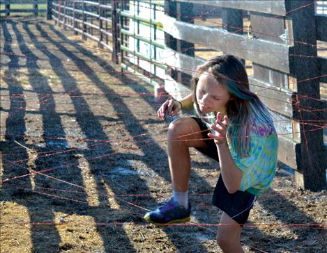 Jessie Griffith, 11, climbs through a watery maze of baling twine.