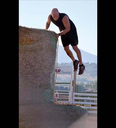 Mark Murphree of Ronan leaps from the top of a round hay bale.