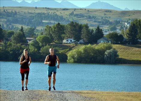 Participants jog up from Flathead River toward the next obstacle.