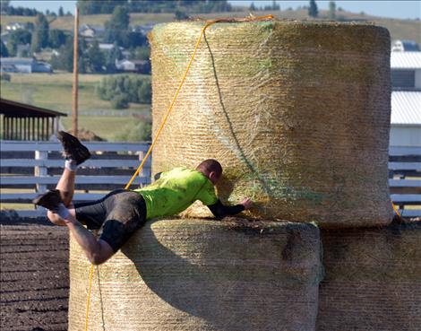 First-place finisher Rob LaBair of Polson, top, climbs a two-story round bale on his way to the finish line.