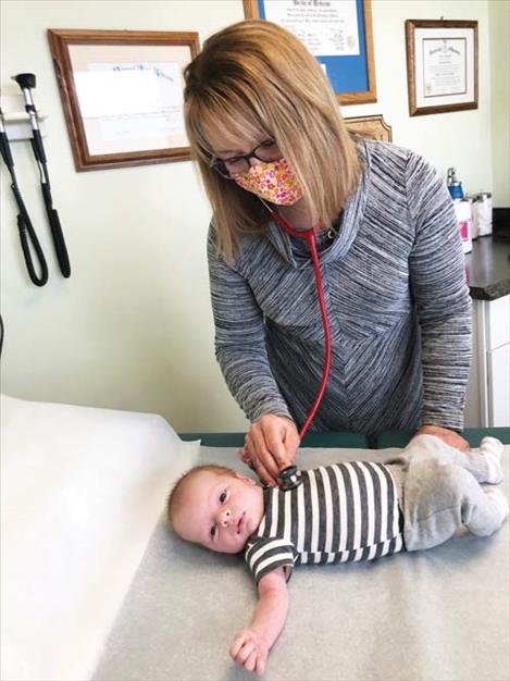 Dr. Cara Harrop examines one of her youngest patients, three-week-old Rhett Van Oort, during a recent checkup at her pureHealth, DPC clinic in Polson.