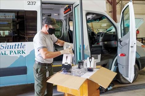 Boles prepares to install hand sanitizers in Glacier National Park shuttles as part of COVID-19 mitigations for a park shuttle. 