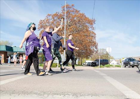 Athlete Kyler Gage leads the Polson Pirate Special Olympics team down Main Street. 