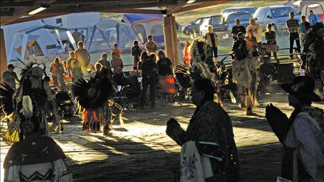 With the sun setting, dancers circle the floor during the evening Grand Entry. 