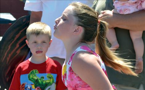 A cherry pit spit contestant lets a pit fly.