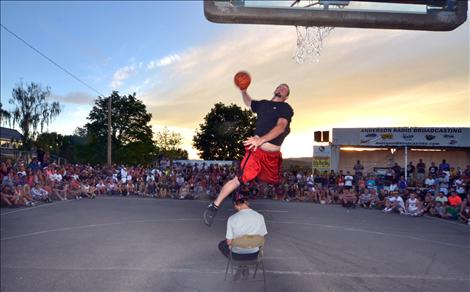 A slam dunk contender pulls out the stops as he leaps over a volunteer obstacle.