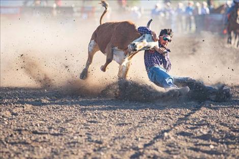 Tyler Houle, of Polson, battles his steer to the ground.