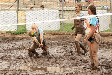 Lauren Buhr of team “Serves You Right” dives through the mud for the ball.