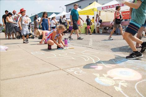  Isabella Mitchell works on her Christmas tree sidewalk chalk art entry.