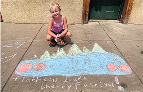 Gracie Goddard sits next to her sidewalk chalk art entry.