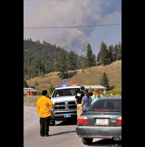 Fire officials talk to Lake County residents Saturday as the smoke from a 1,750 acre fire in Jocko Canyon looms overhead.