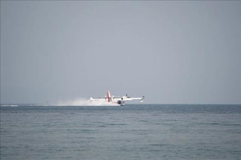 A scooper plane gets water from Flathead Lake.