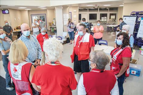 Montana Gov. Greg Gianforte visits with American Red Cross volunteers before touring the Linderman Red Cross evacuation center on Thursday morning.