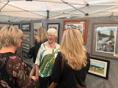 Polson artist  Joanne Simpson visits with admirers at her booth during the Sandpiper Art Festival. 