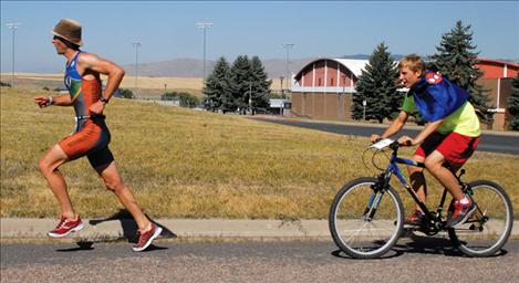 Matt Seeley, Polson Triathalon race director, sprints past Polson High School Saturday followed by his escort Tel Motichka.