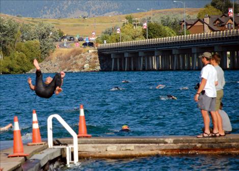 A somersault makes entry into the Flathead River more fun for a male triathlete as he begins the Polson Triathlon.