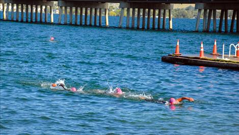 Three triathletes head for the docks at Riverside Park Saturday as they finish their 1.5 kilometer swim, only to head for their bicycles for round two.