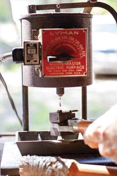 Molten lead drops from an electric furnace to a bullet mold.