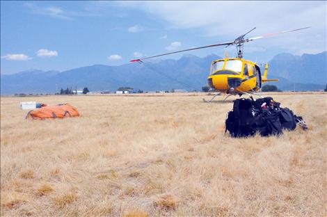 Firefighting gear sits ready to go in front of a helicopter at the St. Ignatius airport.