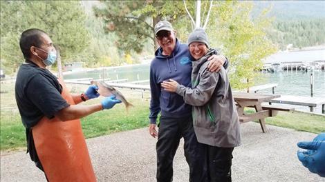 “Freddy Mack,” the $10,000 tagged lake trout, was caught by Terry Krogstad, who is pictured with fishing partner Julie Perkins. The $10,000 tagged fish is held out at left. 