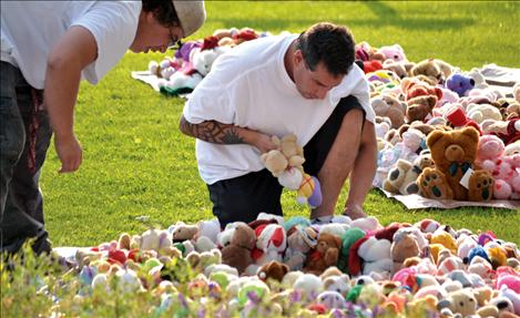Cowen’s friend Chris Irvine, right, and his son Cameron spent hours setting up for Saturday’s garage sale, artistically placing more thousands of bears around the yard.