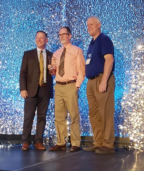 Marion Cooper, center, receives the Caregiver of the Year award from the Montana Hospital Association during the annual Montana Healthcare Conference and Trade Show in Billings.