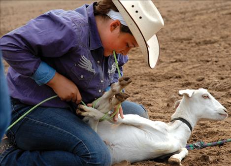 Using a pale green piggin string, Amber Johnson of Conrad ties her goat at the Southwest Youth Rodeo on Aug. 11.  