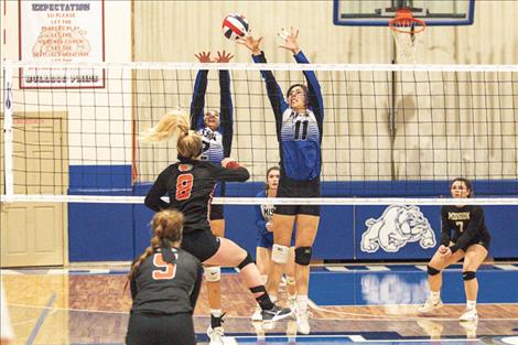 The Mission Lady Bulldogs battle at the net during District 7B tournament action.