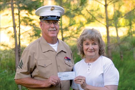 Chuck Lewis, representing Standing for the Fallen, donates funds collected at the Polson Flathead Cherry Festival to Magazines for Troops’ Esther Gunlock.