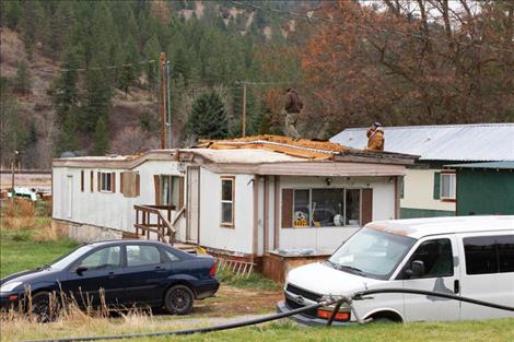 Volunteers check out the damage to the McNutt family’s roof.