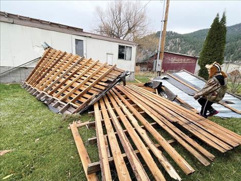 Kyler McNutt walks through some roofing debris after a Nov. 15 windstorm ripped the roof off of his family’s home in Ravalli.