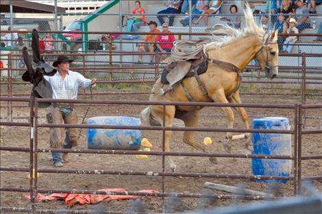 The horse being trained by Levi Guenzler bucks when he flaps a raincoat at it.
