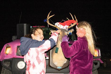 A couple kids give old Rudolph a pat on the nose.