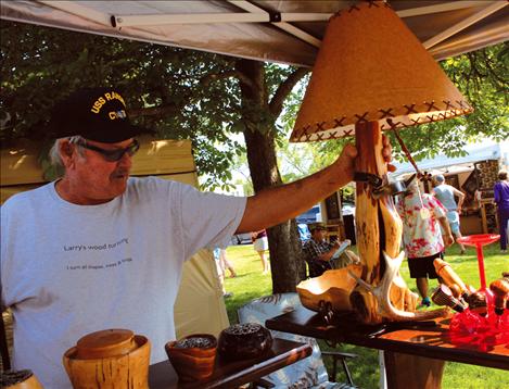 Larry Rosenau demonstrates how a spur turns on a lamp. Rosenau and John Gibbs were at the Sandpiper Art Festival selling wooden items they’ve made.
