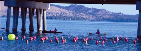 Women and teen triathletes wait for the start of the swim in Flathead River near the Armed Forces Memorial Bridge.