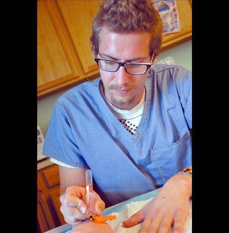 Tommy Marao-Franz of Colorado practices drawing blood in the nursing assistant class at Kicking Horse Job Corps in Ronan. 