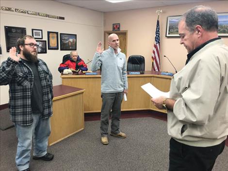 Outgoing Polson Mayor Paul Briney (right) administers the oath of office to new commissioner Jake Holley and incoming Mayor Eric Huffine during last Monday’s meeting. Retiring commissioner Lou Marchello, who also served as Polson’s mayor from 2007-2009, looks on. 