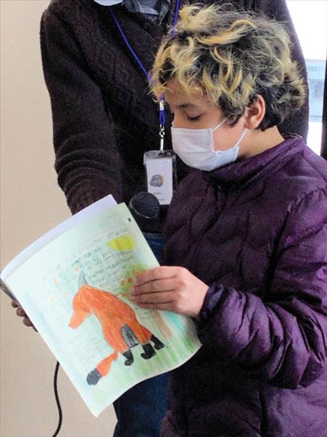 A young poet at St. Ignatius elementary school reads his poetry with a Missoula Writing Collaborative author.