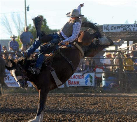 Pistol Creek Rodeo Company supplies stock for Flathead River INFR Tour Rodeo. Above, a Pistol Creek saddle bronc gives a cowboy more than he can handle at Ronan Pioneer Days. At right, Travis Dumont takes a wild ride on another Pistol Creek bronc.