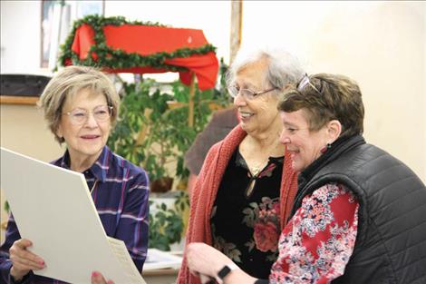 Tillie Marshall and Sharon Sansone, while organizing art for the sale, laugh with Irene over a discovered painting of a pig in a bathtub. Right: Irene speaks with residents who showed their support for the Marchellos as much as their business, visiting to congratulate them and wish Lou a speedy recovery. Many works of art were dropped to 70% off for the gallery’s final sale, leaving attendees excited over valuable finds. 