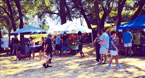 People stroll through Riverside Park Saturday at the chili cook-off Festival for Youth.