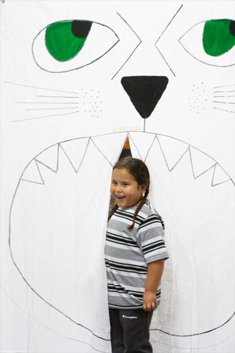 Kindergartener Robert Felix pauses for a photo for his mom as he walks through a giant lion mouth to get to a school hallway filled with art.