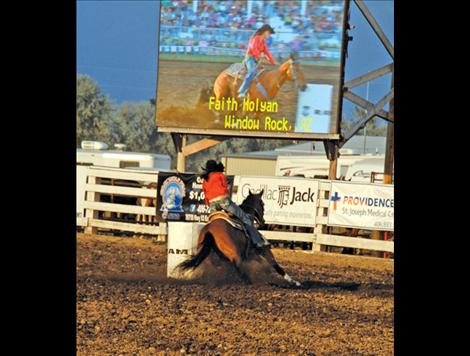 Faith Holyan can be seen in the jumbotron as she rounds a barrel.