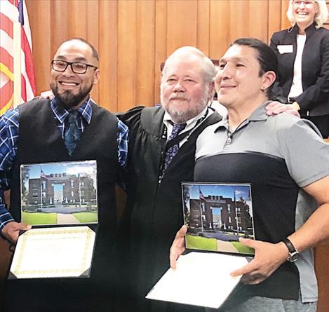 Drug Court graduates Alex Finley and Patrick Matt flank retiring District Court Judge Jim Manley, while Supreme Court Justice Ingrid Gustafson looks on. 