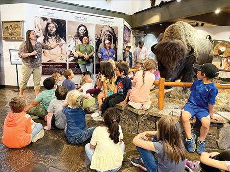Stephanie Gillin, information and education program manager for CSKT Natural Resources, shares with visiting kindergarten students that the stuffed bison bull in the visitor center was about 8 years old and 2,000 pounds when it was taken for the purpose of display and education. Gillin, a wildlife biologist for more than 20 years, also explained that for as big as they are, bison can run up to 35 miles per hour and can make sudden, sharp turns to avoid predators. Keeping a safe, respectful distance between oneself and all wild animals was emphasized.