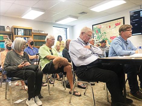 Attorney Doug Wold and son, Clay Wold (foreground), listen as Rocky Point resident Elaine Meeks expresses opposition to a proposed zoning variance that would have allowed short-term rentals in her neighborhood. 