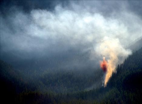 A single-engine air tanker drops fire retardant on the five-acre Eagle Pass fire Saturday morning.